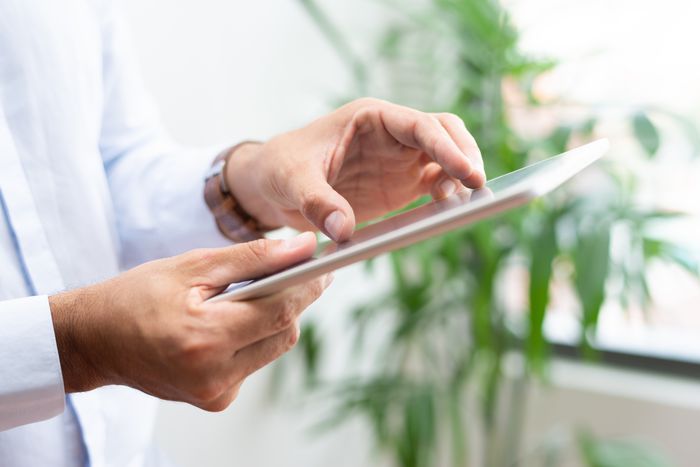 Hand berührt oder wischt über einen Tablet-Bildschirm, Nahaufnahme einer digitalen Bedienung